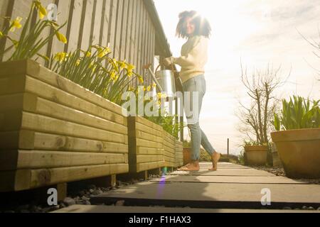 Metà donna adulta fiori di irrigazione Foto Stock