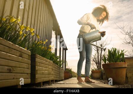 Metà donna adulta fiori di irrigazione Foto Stock