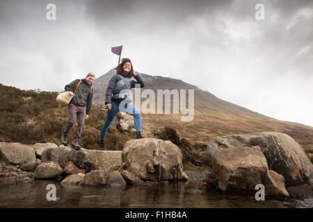 Giovane Varcando il fiume, Fairy Piscine, vicino a Glenbrittle, Isola di Skye, Ebridi, Scozia Foto Stock