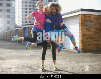 Ritratto di tre donne di indossare abbigliamento sportivo jumping Foto Stock