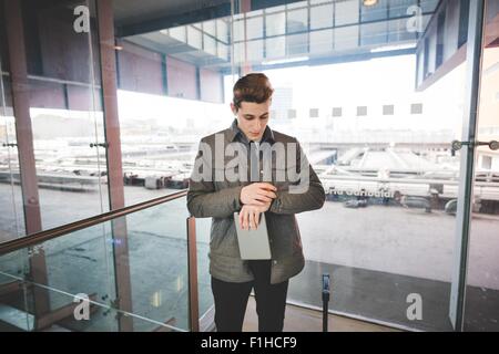 Ritratto di giovane imprenditore " commuter " controllo dell orologio da polso per tempo. Foto Stock