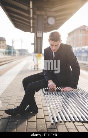 Ritratto di giovane imprenditore utilizzando dei " commuters " tavoletta digitale alla stazione ferroviaria. Foto Stock