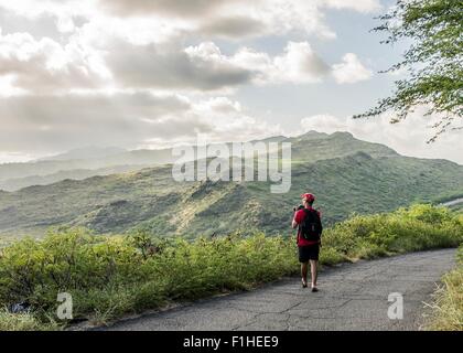 Giovane maschio turistica con la fotografia reflex digitale in Makapuu coast path, Oahu, Hawaii, STATI UNITI D'AMERICA Foto Stock