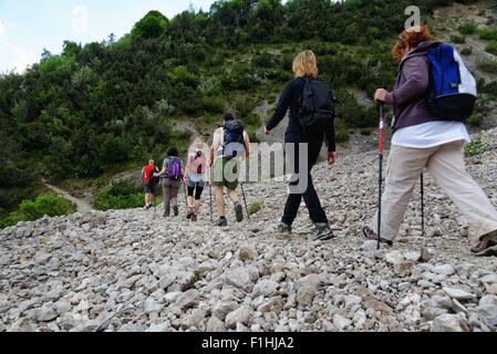 Fila di sei maschio e femmina escursionisti maturo escursionismo in stoney valley Foto Stock