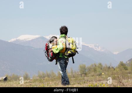 Maschio romantico escursionista che trasportano la fidanzata in armi, Vogogna, Provincia di Verbania, Piemonte, Italia Foto Stock