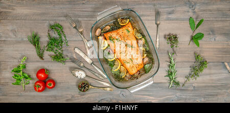 Salmone al Forno di pesci trote con erbe aromatiche e spezie. Cibo sano e background. In stile vintage tonica foto Foto Stock