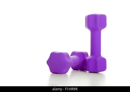 Il concetto di fitness con due manubri viola su sfondo bianco, primo piano Foto Stock