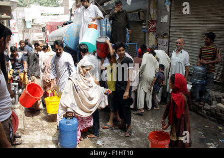 Persone riempiono la loro acqua potabile può a cisterna di acqua a causa della mancanza di acqua potabile nella loro area a Baghbanpura a Lahore Mercoledì, 02 settembre 2015. Foto Stock