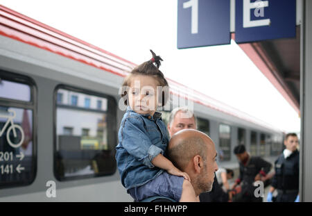 Rosenheim, Germania. 2 Sep, 2015. Un uomo dalla Siria porta una bambina mentre si cammina in un ufficio di registrazione, presso la stazione ferroviaria in Rosenheim, Germania, 2 settembre 2015. La polizia arrestati 50-60 rifugiati (soprattutto dalla Siria), in un treno in arrivo dall'Italia. Foto: ANDREAS GEBERT/dpa/Alamy Live News Foto Stock