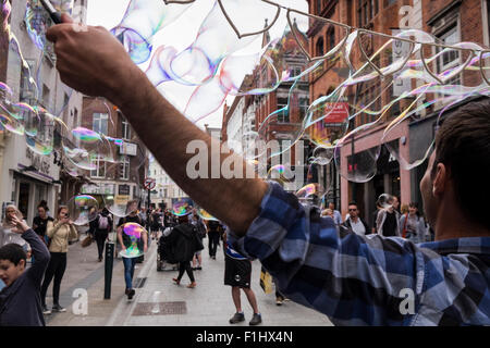 Buskers rendendo le bolle di sapone su Grafton Street a Dublino, Irlanda. Foto Stock