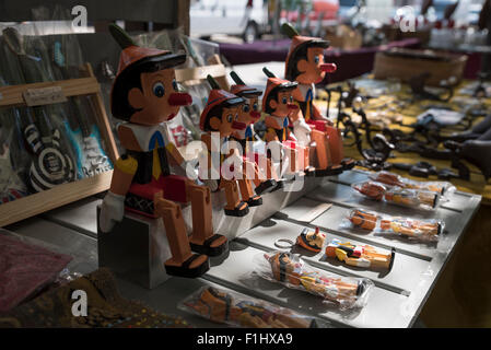 Giocattoli di Pinocchio in legno e altri oggetti di interesse in vendita al mercato del sabato lungo il Dijver accanto al canale, Bruges. Foto Stock