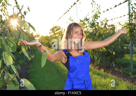 Una femmina di giardiniere con outstreched armes in serra Foto Stock