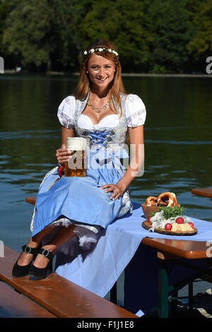 Dpa-esclusivo - Il 'Oktoberfest' Wiesn playmate 2015, Jessica Kuehne pone in un tradizionale bavarese 'Dirndl' abito, in un giardino della birra al lago Kleinhesseloh a Monaco di Baviera, Germania, il 29 agosto 2015. Foto: Felix Hoerhager/dpa Foto Stock