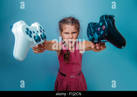 Ragazza aspetto europeo dieci anni detiene due joystick per giochi nel suo Foto Stock