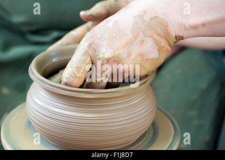 A vasai mani lavorando argilla sul tornio del vasaio Foto Stock