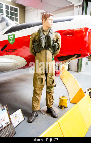 Maschio di manichino vestito negli anni sessanta Royal Air Force, RAF battenti seme con il rosso e bianco trainer aeromobile dietro di lui. Display del museo. Foto Stock