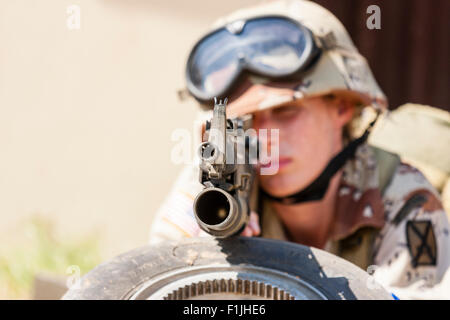 Esercito Americano, Black Hawk rievocazione, Guerra e Pace show. Soldato donna posa rivolta verso il basso, puntando la pistola direttamente al visualizzatore. Focus sul muso della pistola. Foto Stock