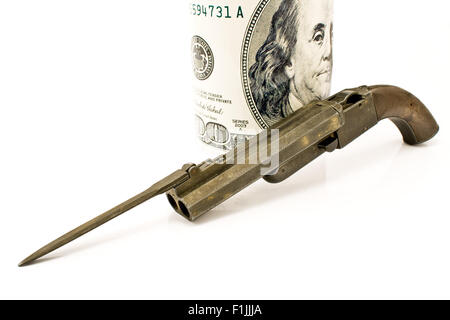 Vecchia pistola con baionetta e centinaia di dollari isolato su bianco Foto Stock
