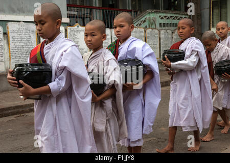 Novizi, giovani suore in piedi in linea per il cibo nel monastero Mahagandayon, Amarapura, Divisione Mandalay, Myanmar Foto Stock