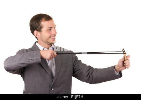 Bel buisness uomo sorridente concentrata di puntamento di un slingshot isolate su sfondo bianco Foto Stock