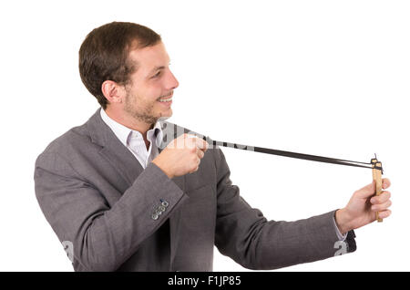 Bel buisness uomo sorridente concentrata di puntamento di un slingshot isolate su sfondo bianco Foto Stock