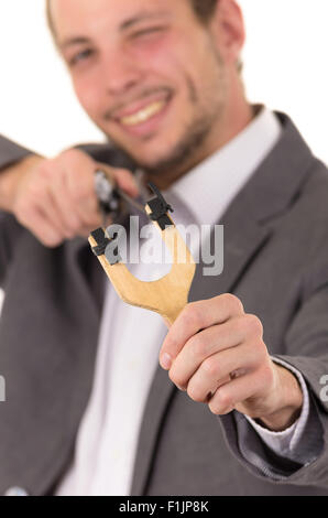 Bel buisness uomo sorridente concentrata di puntamento di un slingshot isolate su sfondo bianco Foto Stock