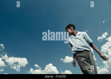 Scuola africana pupillo gioca con un pallone da calcio Foto Stock