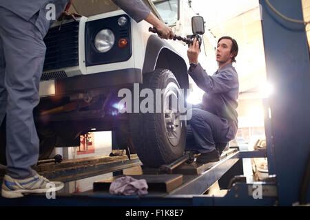 Meccanica a lavorare nel negozio di riparazioni auto Foto Stock