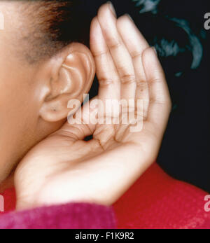 Donna nera mano cupping over ear Foto Stock