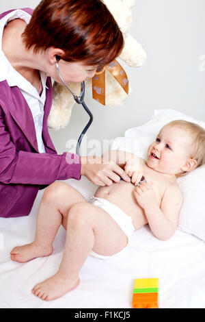 Un pediatra ascoltando un bambino di respirazione Foto Stock