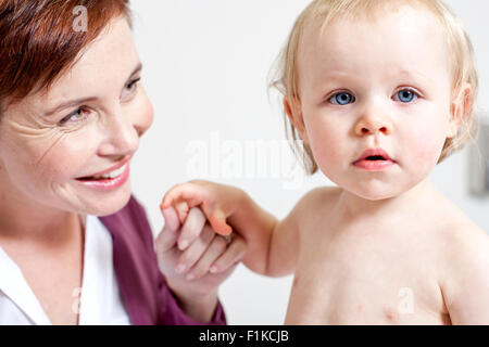 Close up di un pediatra tenendo un bimbo di mani Foto Stock