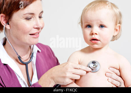 Un pediatra ascoltando un bambino di respirazione Foto Stock