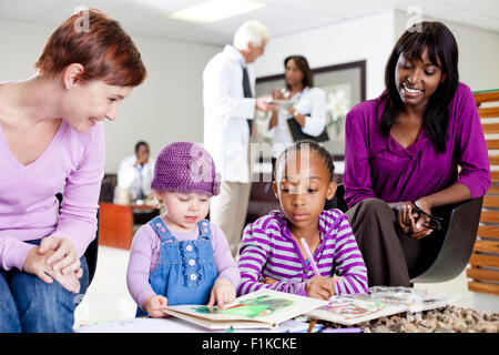 Due famiglie in sala di attesa Foto Stock
