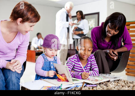 Due famiglie in sala di attesa Foto Stock