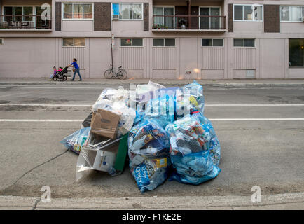 Blu di riciclaggio di plastica Sacchi per immondizia messo fuori per il riciclaggio in strada, attesa per la raccolta dei rifiuti. Foto Stock