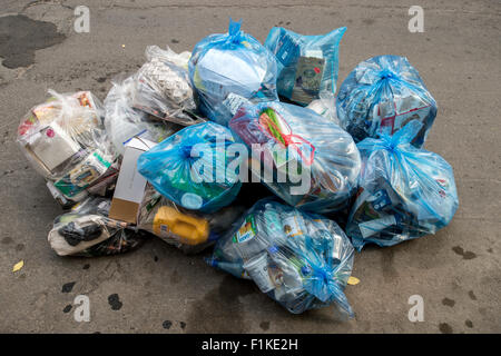 Blu di riciclaggio di plastica Sacchi per immondizia messo fuori per il riciclaggio in strada, attesa per la raccolta dei rifiuti. Foto Stock