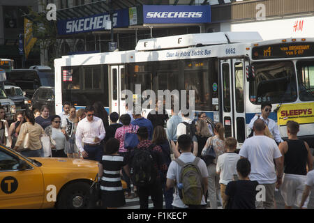 Vi è sempre un traffico di pedoni e automobili e autobus presso la Quinta Avenue e la 42th Street nel cuore di Manhattan. Foto Stock