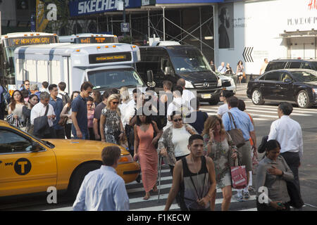 Vi è sempre un traffico di pedoni e automobili e autobus presso la Quinta Avenue e la 42th Street nel cuore di Manhattan. Foto Stock