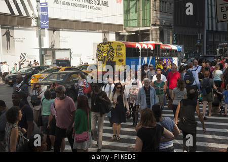 Vi è sempre un traffico di pedoni e automobili e autobus presso la Quinta Avenue e la 42th Street nel cuore di Manhattan. Foto Stock