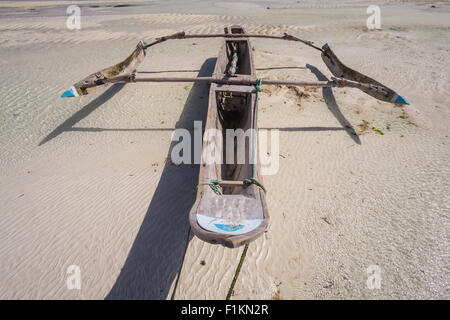 Dhow imbarcazione in legno che giace a secco a bassa marea su una spiaggia all'Oceano Indiano vicino a Zanzibar, Tanzania Foto Stock