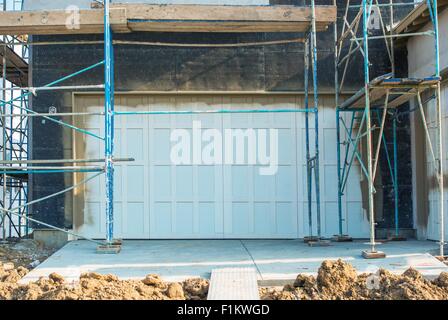 Porta di Garage costruzione. Residenziale di nuova costruzione casa closeup sulle porte di garage e di ponteggi. Zona residenziale Devel Foto Stock