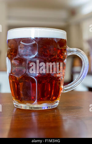 La birra in un vetro satinato spesso chiamato un bicchiere con manico Foto Stock