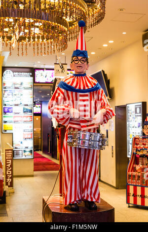 Giappone, Osaka. Dotonbori. Il clown mascotte negozio di souvenir di Kuidaore Taro, una icona di Dotobori. Pagliaccio grande batterista figura nella lobby. Foto Stock