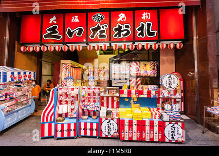 Giappone, Osaka. Dotonbori, esterna del clown mascotte negozio di souvenir di Kuidaore Taro, una icona di Dotobori. Varie Kuidaore Taro prodotti in vendita. Foto Stock