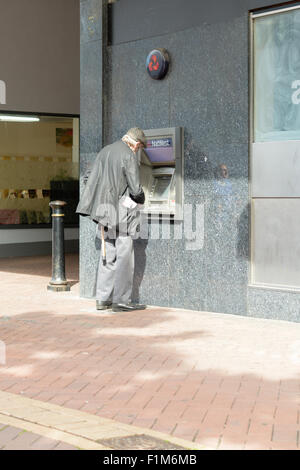 L'uomo ritirare contanti da una Natwest Bank bancomat in Bedford, Bedfordshire, Inghilterra Foto Stock