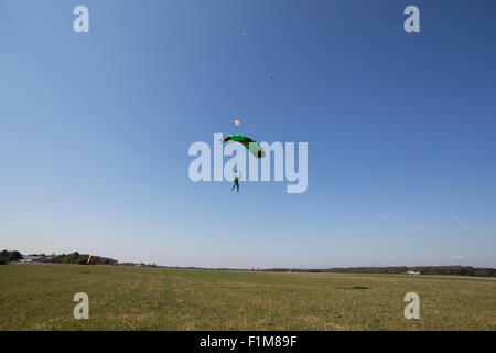 Paracadutista sotto la tettoia si sta avvicinando alla zona di sbarco dopo una divertente skydive il salto nel blu del cielo. Foto Stock