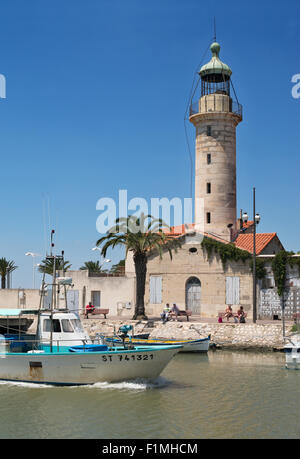 La pesca in barca passando faro, Le Grau-du-Roi, Languedoc-Roussillon, Francia, Europa Foto Stock