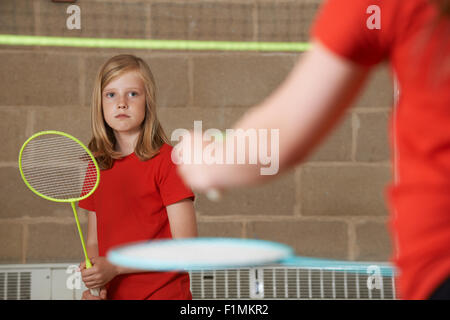 Due ragazza che gioca Badminton nella palestra della scuola Foto Stock
