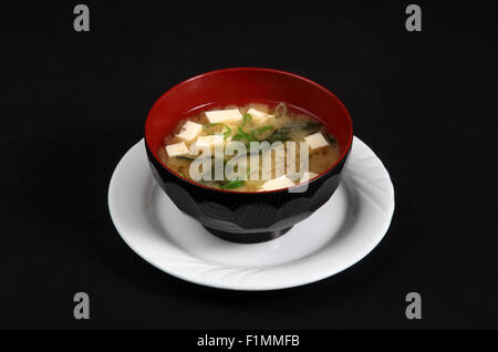 Bacino con la zuppa di pesce su uno sfondo nero Foto Stock