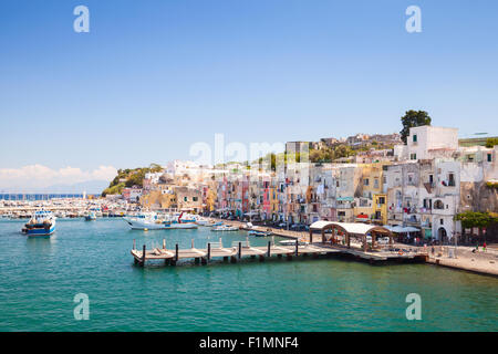 Italiana piccola città costiera paesaggio con case colorate e pontili. Porto di Isola di Procida, il Golfo di Napoli, Italia Foto Stock